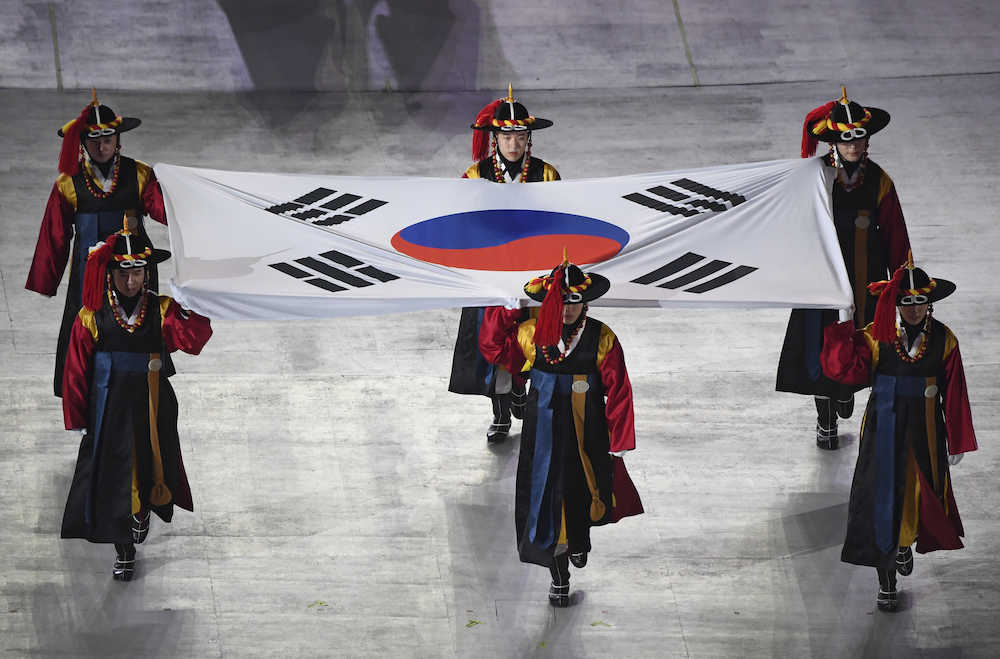 民族衣装を着たパフォーマーたちによって競技場に入場した大韓民国の国旗（ＡＰ）