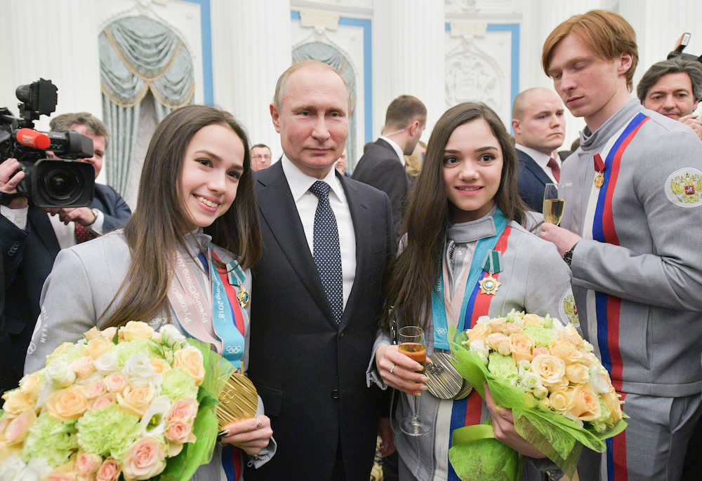 モスクワの大統領府で開かれた勲章授与の式典後、記念撮影する（左から）アリーナ・ザギトワ選手、プーチン大統領、エフゲニア・メドベージェワ選手