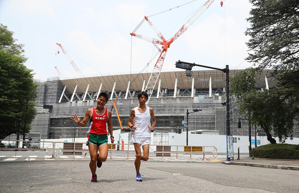建設中の新国立競技場を背に走るＭ高史（左）とポップライン萩原（撮影・会津　智海）