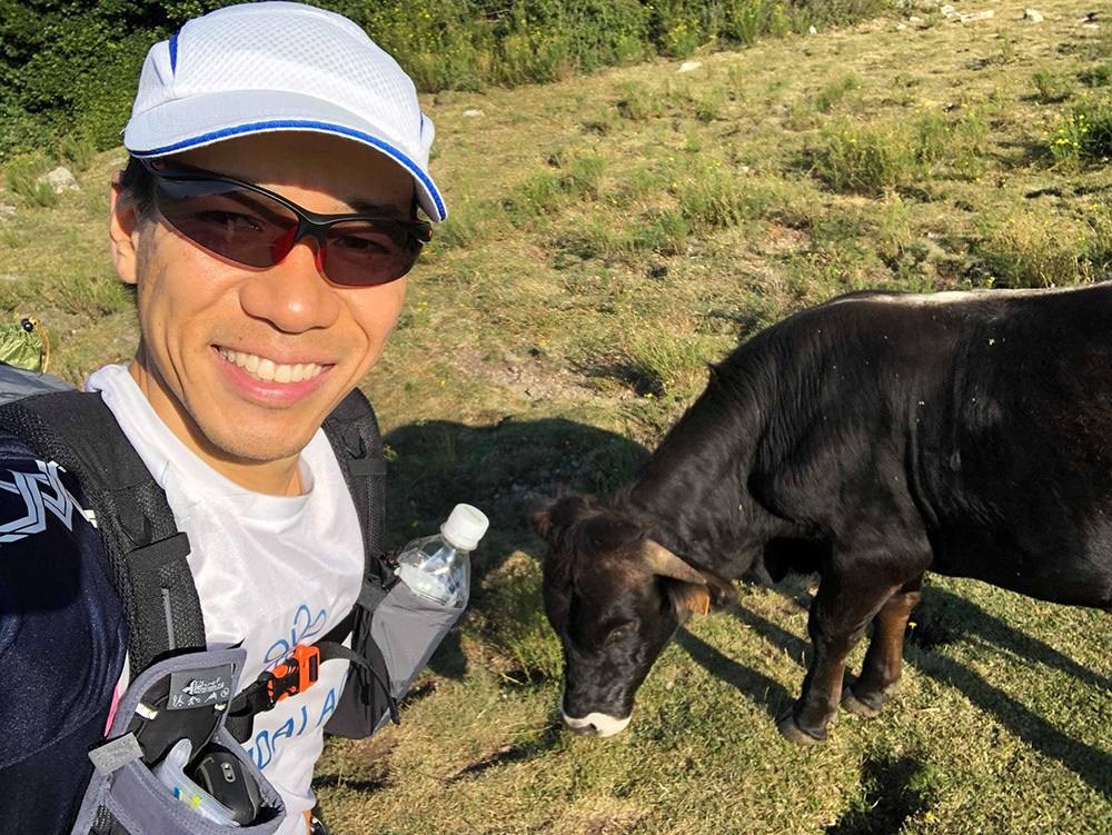 ＜１日目＞コースにいた牛とのツーショット写真を撮る北田氏