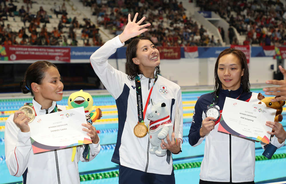 ＜アジア大会競泳＞女子４００メートル個人メドレー決勝、笑顔で手を振る金メダルの大橋悠依（左から２人目）と銅メダルの清水咲子（左）＝撮影・小海途　良幹