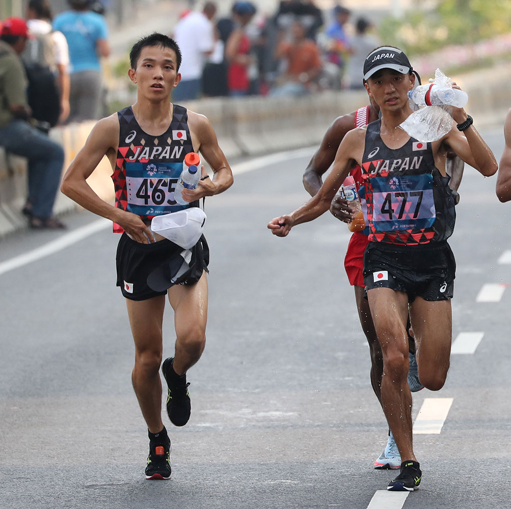 アジア大会男子マラソンで、バッグの中に入っている保冷剤で体を冷やす井上大仁（左）。右は園田隼
