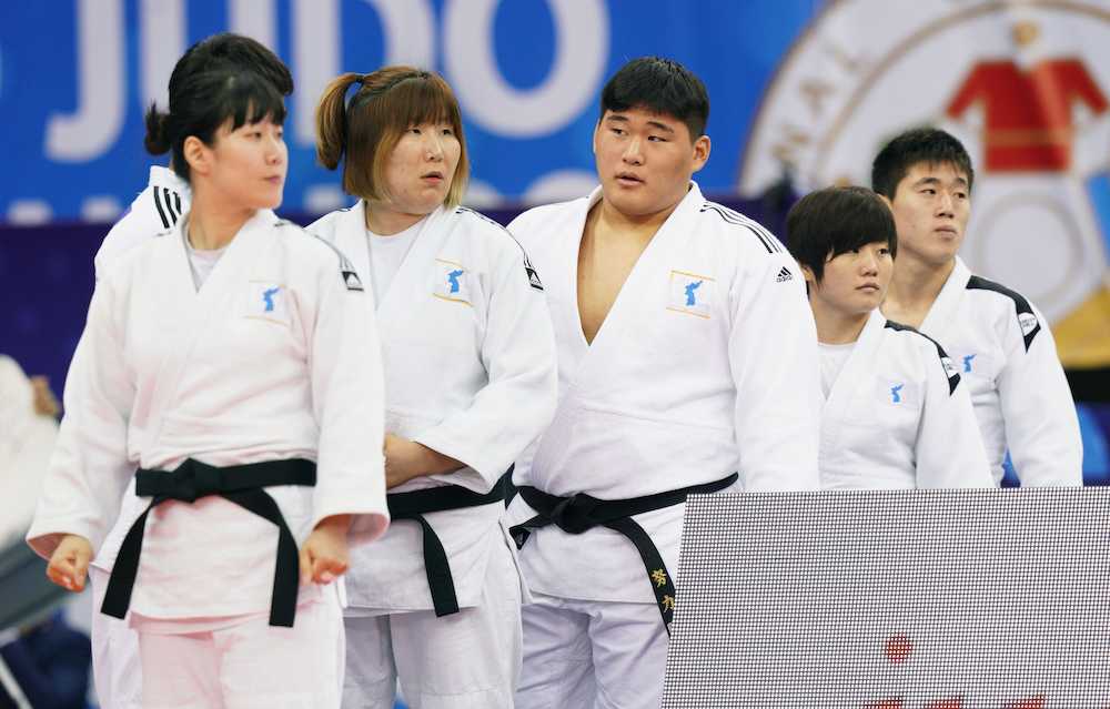 柔道の世界選手権で、男女混合団体に臨む北朝鮮（右側の２人）と韓国の南北合同チーム「コリア」の選手たち。胸に統一旗を付けている