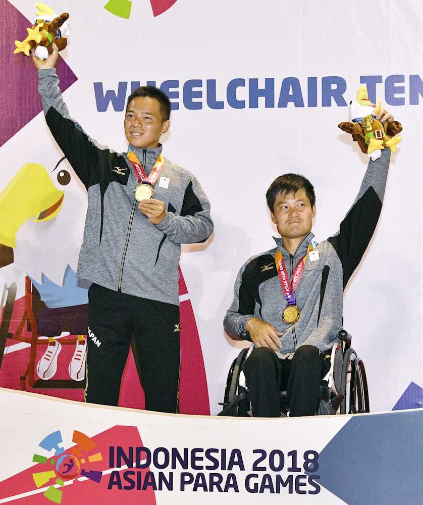 車いすテニス男子ダブルスで優勝し、金メダルを手にする国枝（右）、真田組