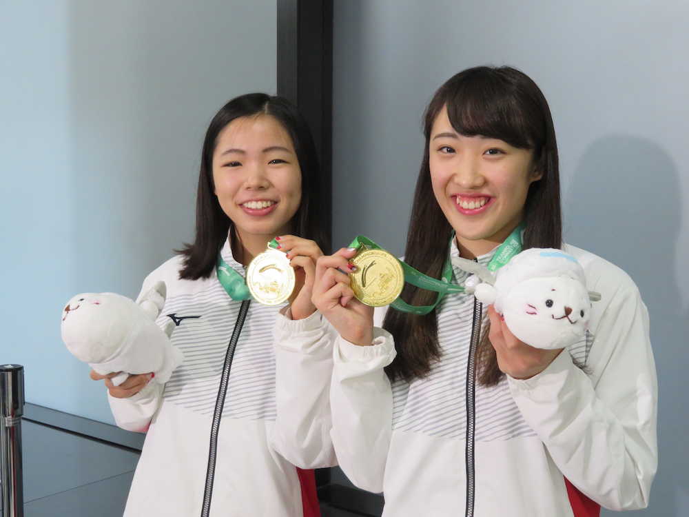 トランポリン世界選手権から帰国し、金メダルを手に笑顔の宇山（左）と森