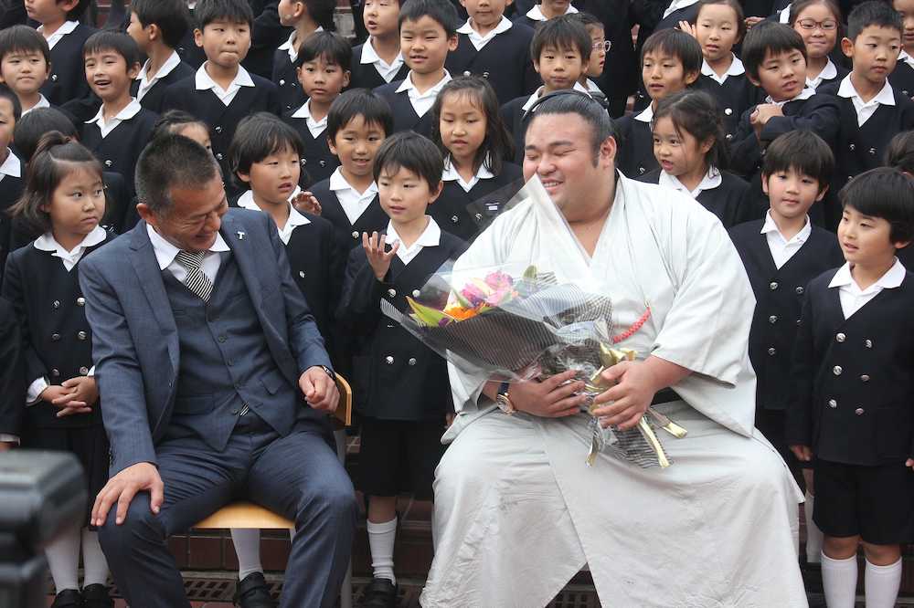 仁川学院小の後輩たちに囲まれながら、恩師の橋本教諭（左）と九州場所の談義に花を咲かせて笑顔を見せる貴景勝