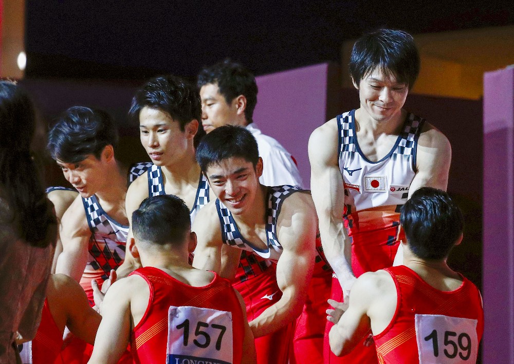 １０月の世界選手権の表彰式で、中国選手（手前）と握手する内村（右）ら