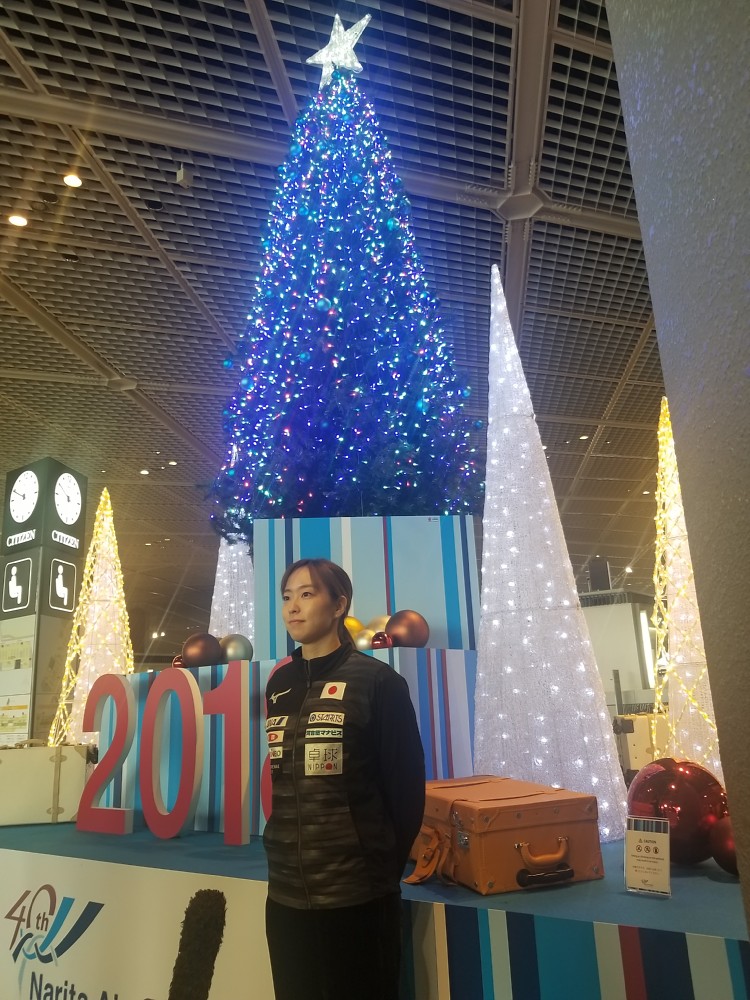 クリスマスツリーを背に報道陣の質問に答える石川佳純