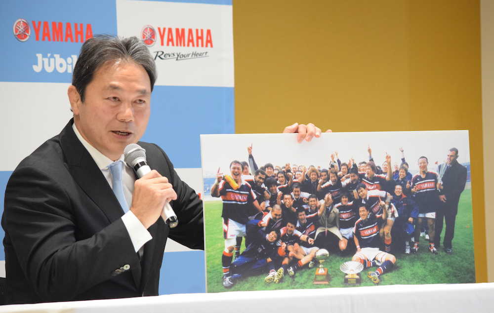 ２００２年の関西社会人Ａリーグ優勝時の写真を手に思いを語る清宮監督