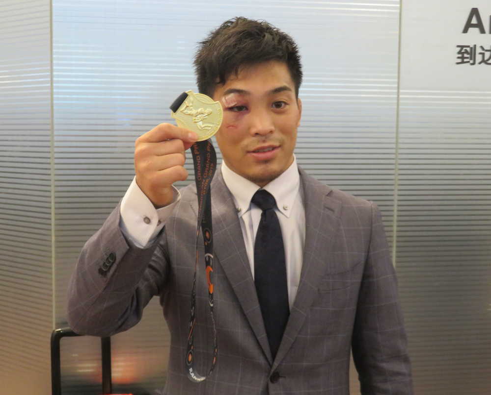 欧州遠征から帰国したレスリング太田。負傷した右目の横でハンガリーＧＰの金メダルを掲げる