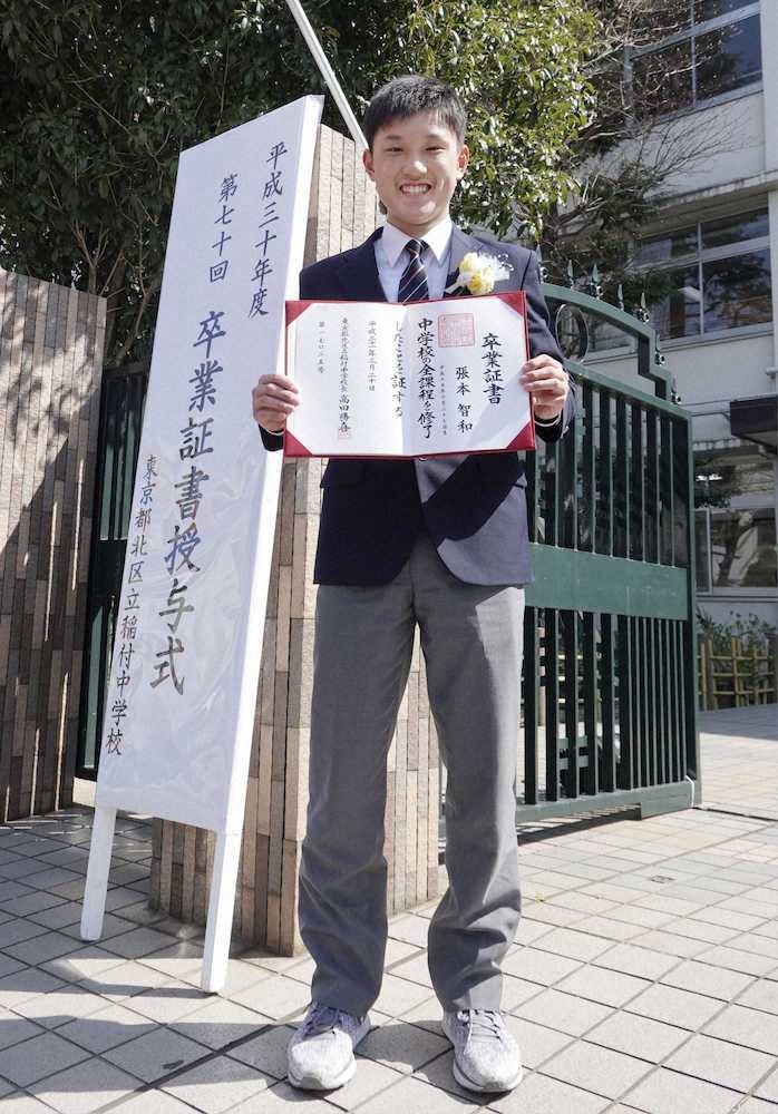 東京・稲付中の正門前で、卒業証書を手にする卓球男子の張本