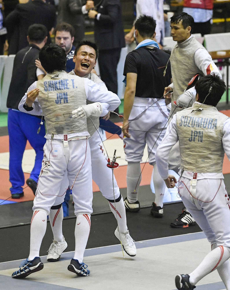 フェンシングアジア選手権男子フルーレ団体決勝で中国を破り、敷根（左手前）と抱き合って喜ぶ松山