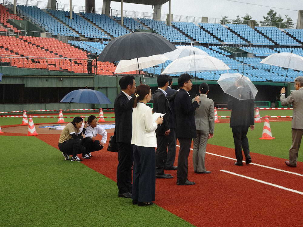 ソフトボール日本代表の宇津木麗華ヘッドコーチ（左から2人目）と山田恵里主将（左端）は、しゃがんでグラウンドの傾斜を確認した