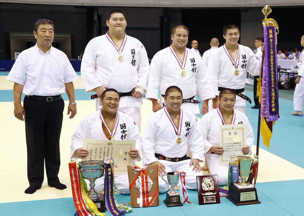 男子団体で優勝し、笑顔で記念撮影する斉藤（上段・左から2人目）ら国士舘の選手