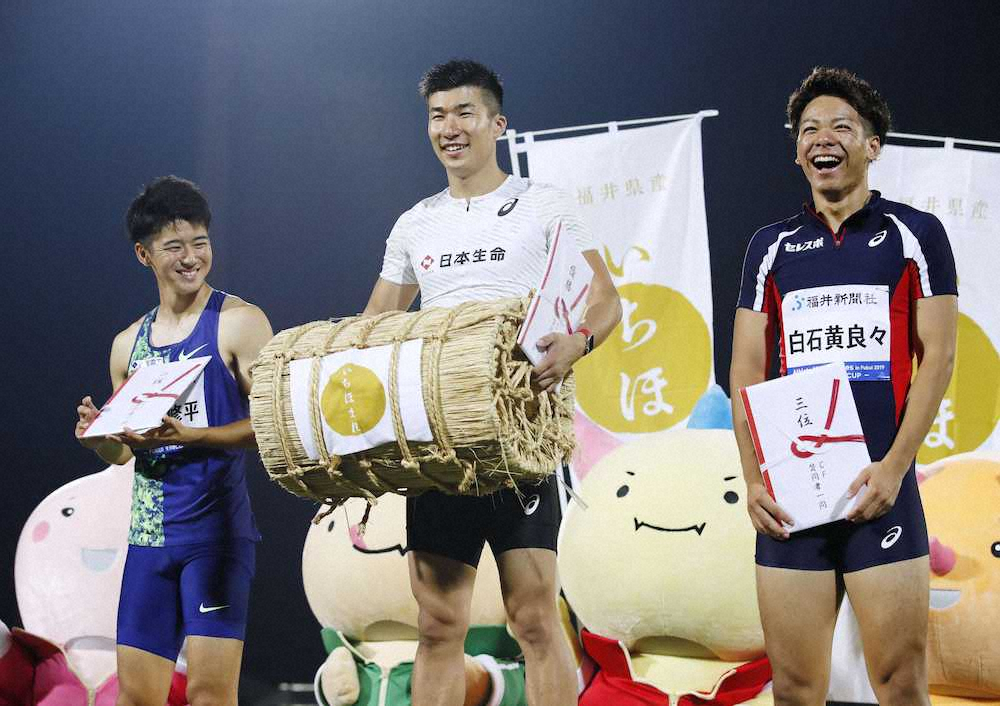 男子100メートルで優勝し、表彰式で笑顔を見せる桐生（中央）。左は2位の多田、右は3位の白石