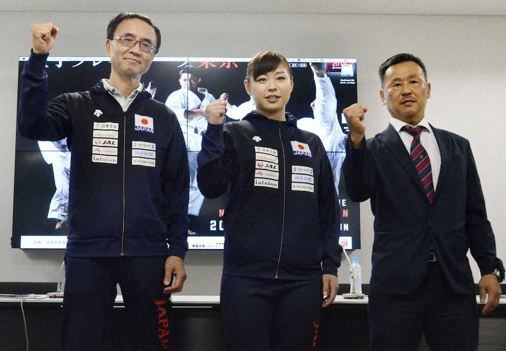 空手のプレミアリーグ東京大会に向けた記者会見でポーズをとる女子組手68キロ超級の植草歩（中央）。左は林晃・男子組手監督、右は中野秀人・女子組手監督