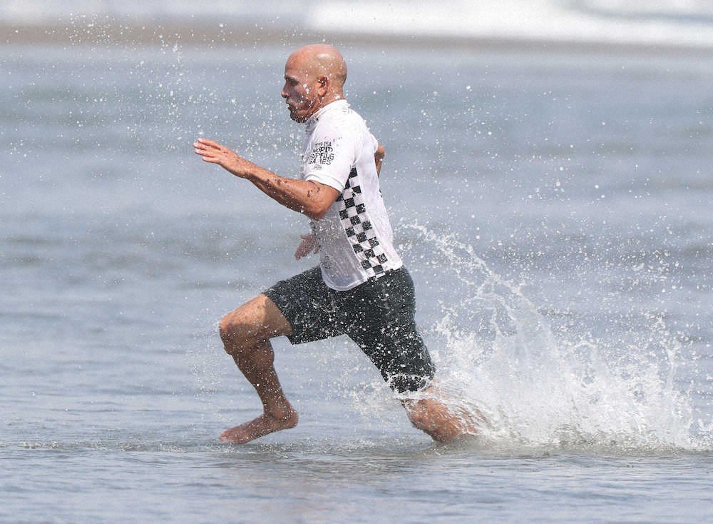 ＜2019WORLD　SURFING　GAMES　＞アロハカップ決勝、走って浜辺に向かう向かケリー・スレーター（撮影・岡田　丈靖）