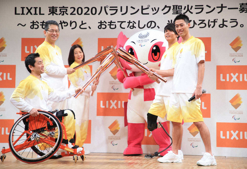 笑顔を見せながらトーチキスする（左から）長島選手、瀬戸会長、佐竹本部長、ソメイティ、佐藤選手、錦織