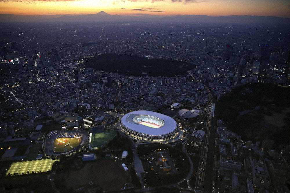 　照明がともされた国立競技場。左奥は富士山（共同通信社ヘリから）