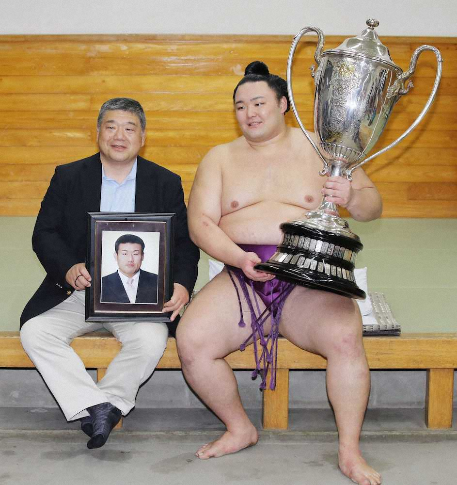 2019年5月、近大相撲部の伊東勝人監督（左）と写真に納まる朝乃山。遺影は富山商の恩師、浦山英樹さん