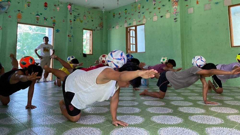 サッカーボールを使ってオンラインレッスンを受けるミャンマーの施設「ドリームトレイン」の子どもたち（ジャパンハート提供）