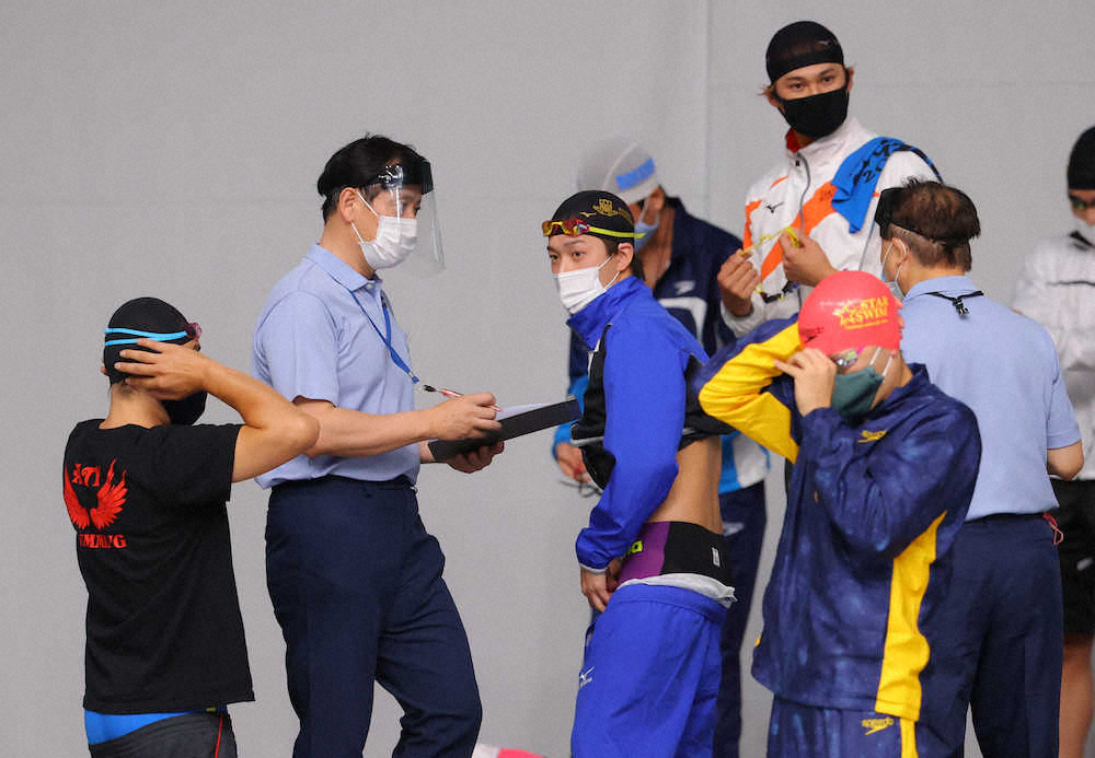 ＜東京都特別水泳大会＞レース前、役員、選手はマスクやフェースガードを着けて待機所に集まる