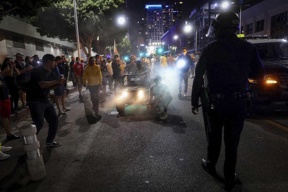 ロサンゼルス市内でレイカーズ・ファンの騒ぎを収めようとする警察官（AP）