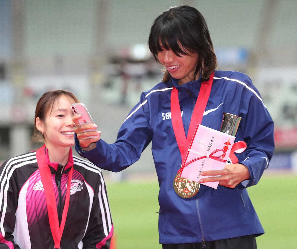 ＜陸上日本選手権　　女子子10000M＞表彰台で自撮りを始める新谷仁美（右）（撮影・北條　貴史）