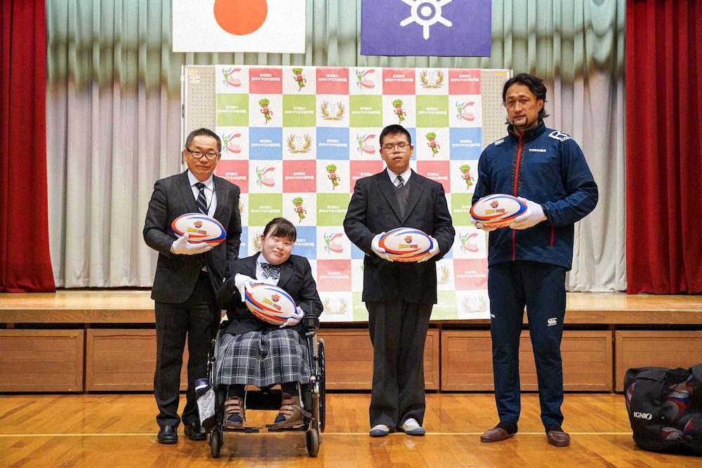 東京都立府中けやきの森学園にラグビーボールを贈呈した東芝の大野均氏（右端）（CTOSHIBA　BRAVE　LUPUS　/　写真:東芝ブレイブルーパス）
