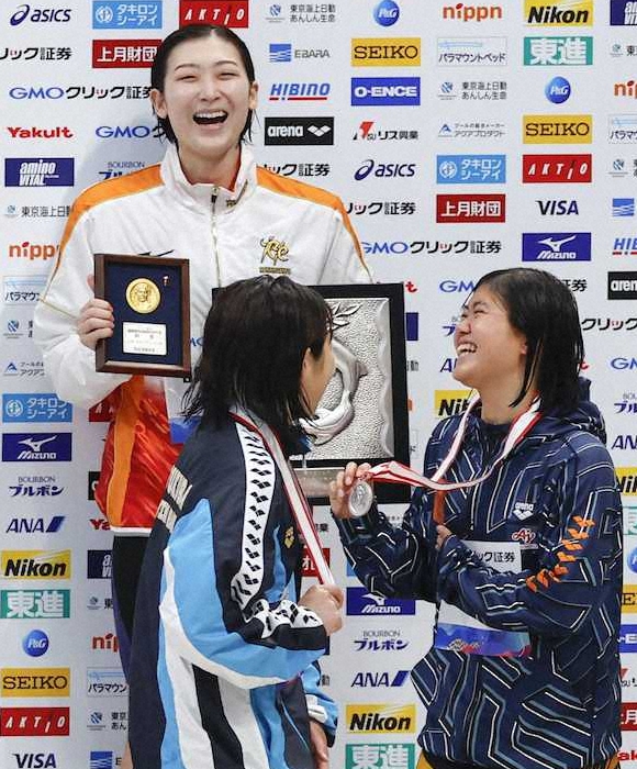 競泳日本選手権兼東京五輪代表選考会第2日、女子100メートルバタフライで優勝し、表彰台で笑顔の池江璃花子（奥）