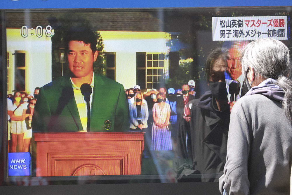 松山の優勝スピーチを東京のテレビの前で見守る男性（AP）