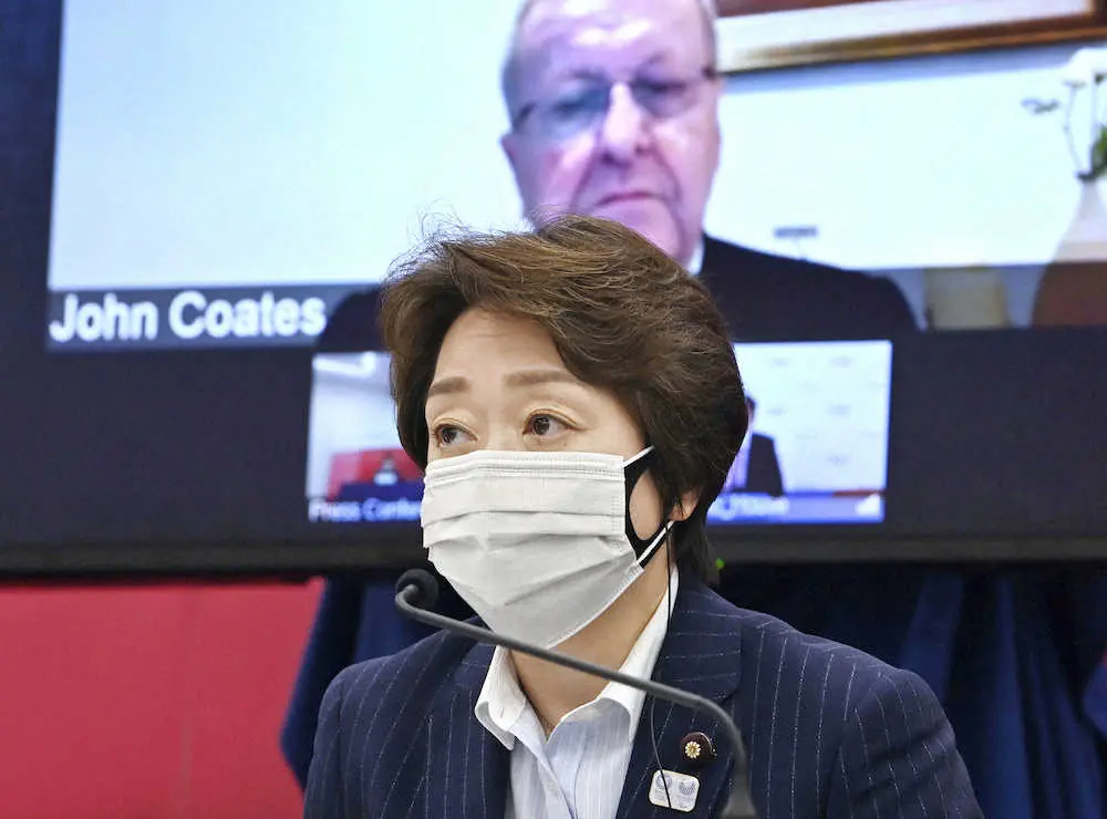 記者会見する東京五輪・パラリンピック大会組織委の橋本会長。モニター内はIOCのコーツ調整委員長