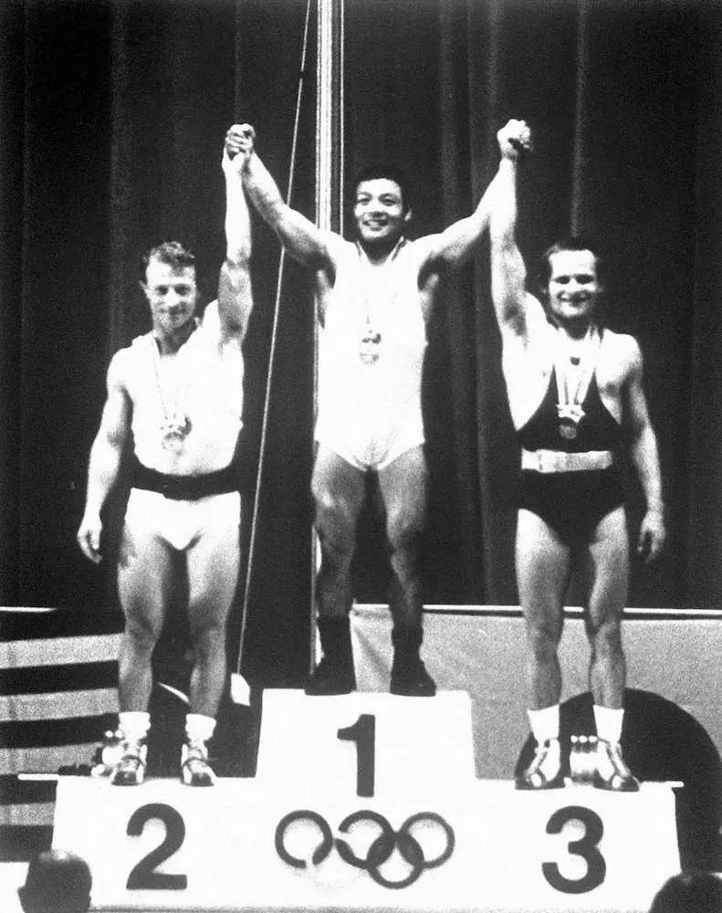 日本の金メダル第1号に輝き、表彰台の中央で笑顔を見せる三宅義信＝1964年10月