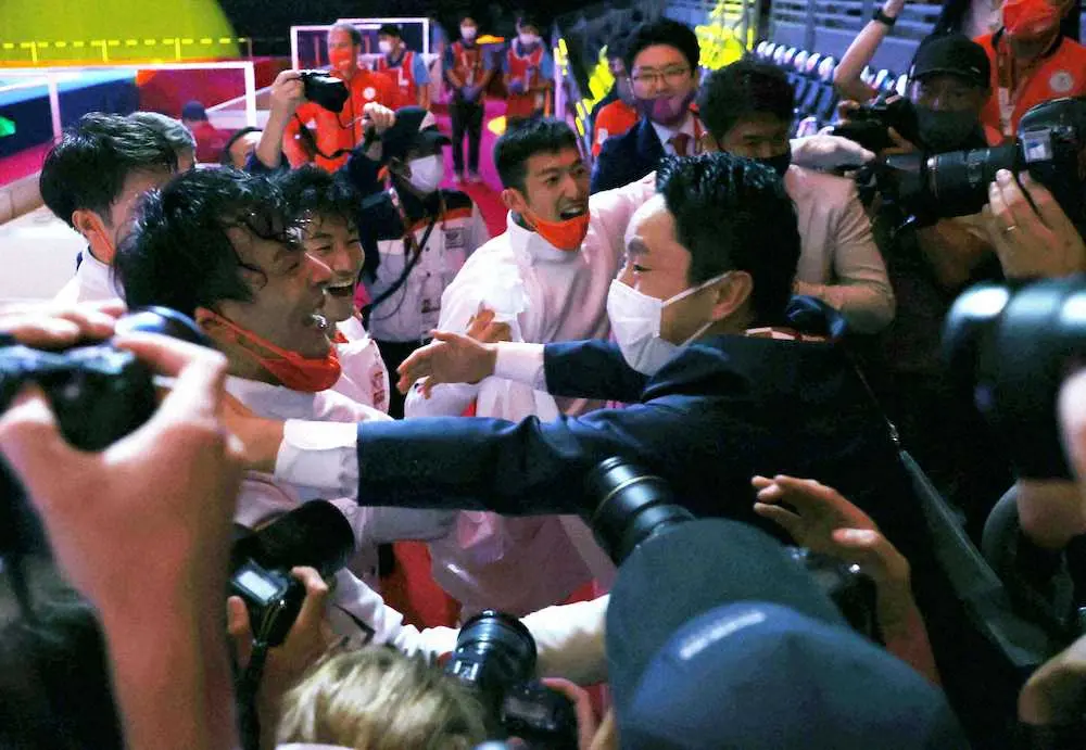 男子エペ団体で金メダルを獲得した日本チームを祝福する日本フェンシング協会の太田雄貴前会長