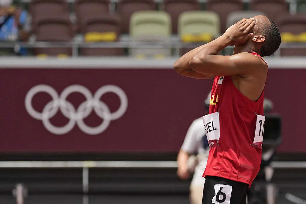 男子100メートル予備予選、フライングで失格となり、頭を抱えるアンゴラのアベニ・ミゲル（AP）