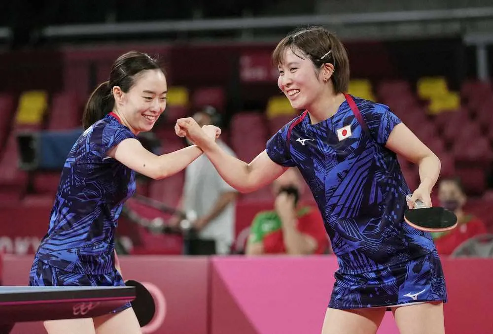 卓球女子団体1回戦　ハンガリー戦の第1試合に勝利し、笑顔でタッチを交わす石川（左）、平野組