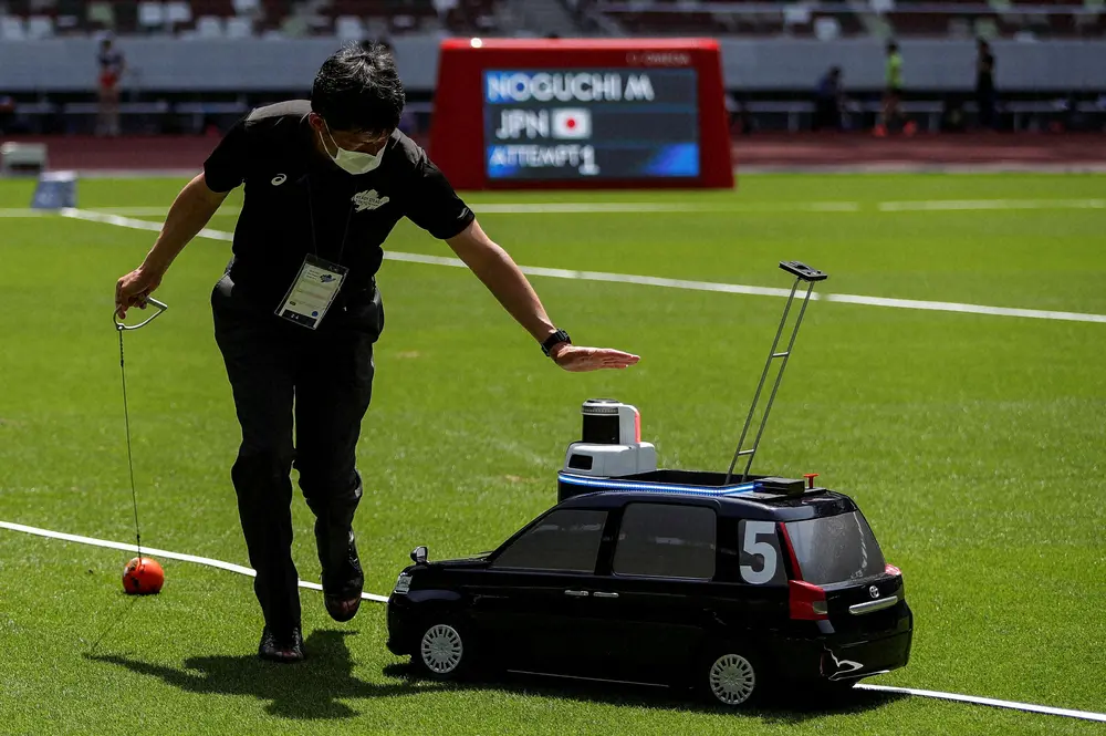今年5月、東京五輪のテスト大会でハンマーを回収するロボットカー（ロイター）