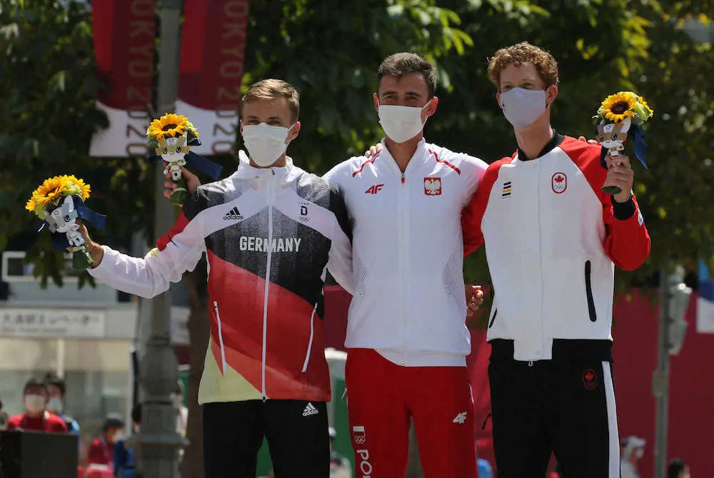 ＜東京五輪　男子50キロ競歩＞3位となったカナダのダンフィー（右）はフラワーセレモニーで喜ぶ（左から2位のドイツのヒルベルト、1位のポーランドのトマラ）（撮影・西海健太郎）