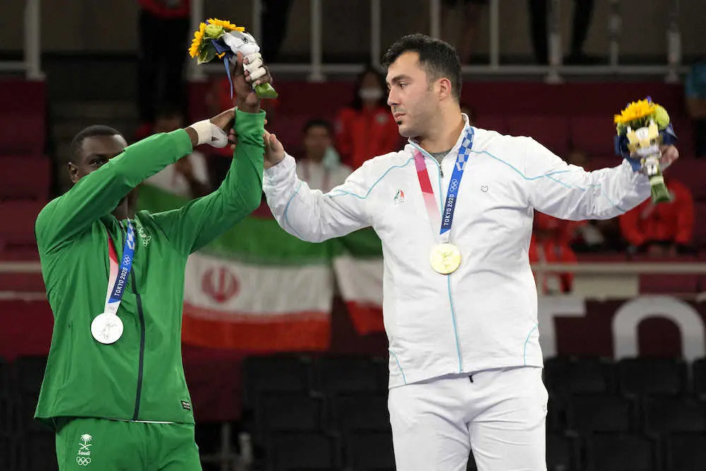 男子空手組手75キロ超級で金メダルのガンジザデ(右)とハメディはお互いを称えあう（AP）