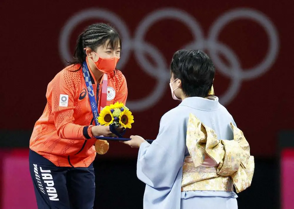 女子50キロ級で優勝し、伊調馨（右）からブーケを受け取る須崎優衣
