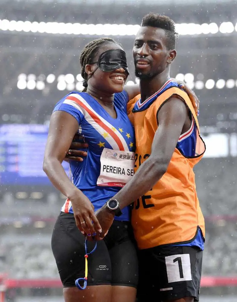 陸上女子200メートル（視覚障害T11）予選のレース後に、伴走者からの求婚を受け入れ、笑顔で抱き合うカボベルデ代表のケウラニドレイア・ペレイラセメド（左）（共同）