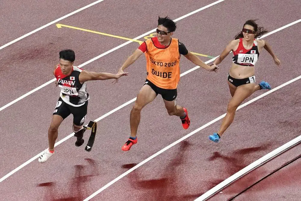 　400メートルユニバーサルリレー決勝　第1走者の沢田優蘭（右）から第2走者の大島健吾（左）にリレー＝国立競技場
