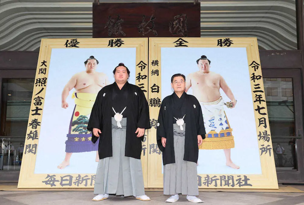 贈呈された優勝額の前に立つ照ノ富士（左）と白鵬の代理で出席した高島親方