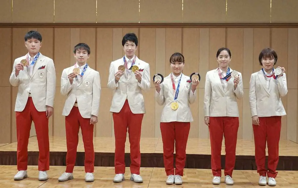 日本卓球協会の東京五輪報告会で、メダルを手にポーズをとる（左から）張本、丹羽、水谷、伊藤、石川、平野