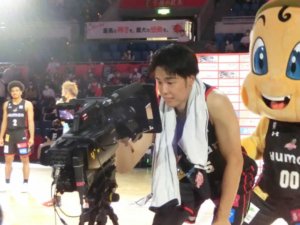 マン・オブ・ザ・ゲームに選ばれた大阪エヴェッサ・竹内がテレビカメラにサイン
