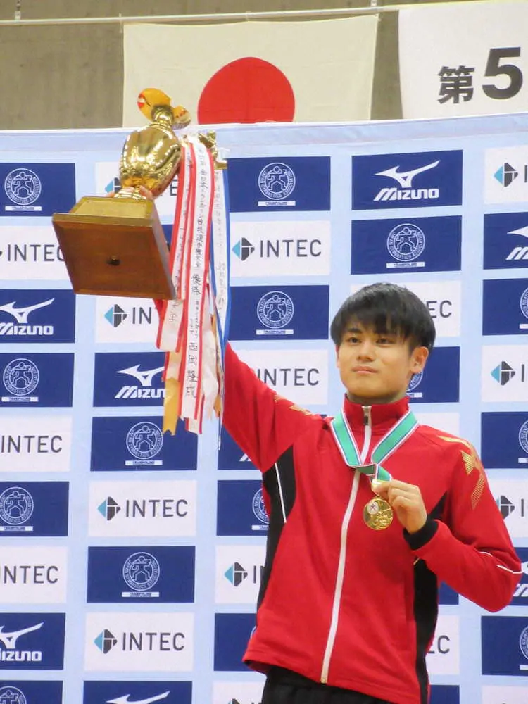 全日本選手権で2連覇を達成しトロフィーを掲げる西岡