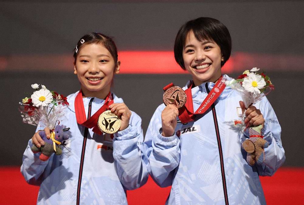世界体操種目別決勝　種目別平均台の表彰式で金メダルを手にする芦川うらら（左）と銅メダルの村上茉愛