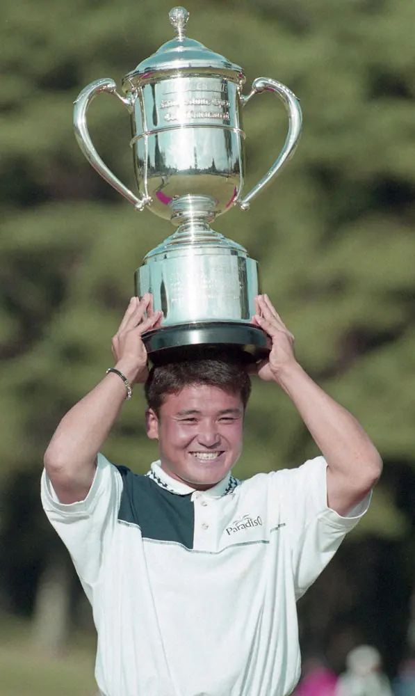 99年、ブリヂストン・オープンで優勝し、カップを頭上に笑顔を見せる丸山