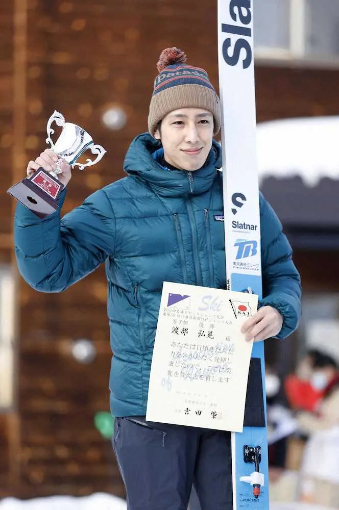男子で優勝し、表彰式でトロフィーを掲げる渡部弘晃