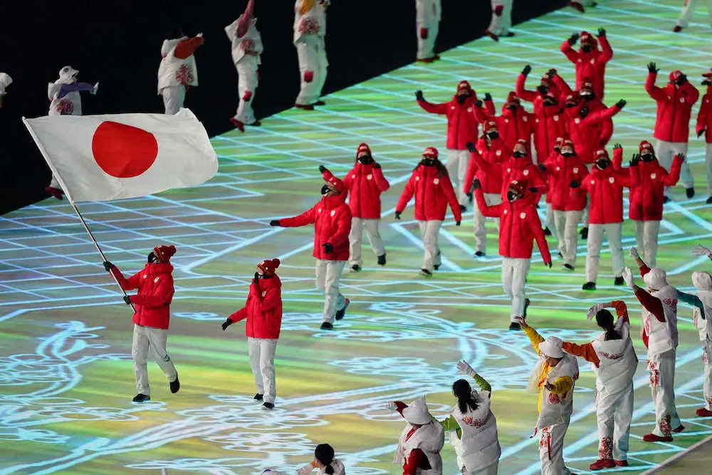 旗手の渡部暁斗と郷亜里砂を先頭に手を振りながら入場行進する日本選手団（AP）
